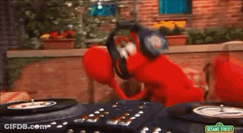 Elmo From Sesame Street Is Wearing Headphones And Playing Records . GIF