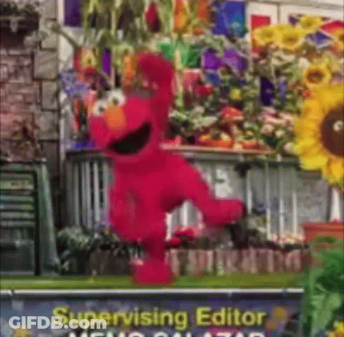 Elmo Is Dancing In Front Of A Sign That Says Supervising Editor GIF