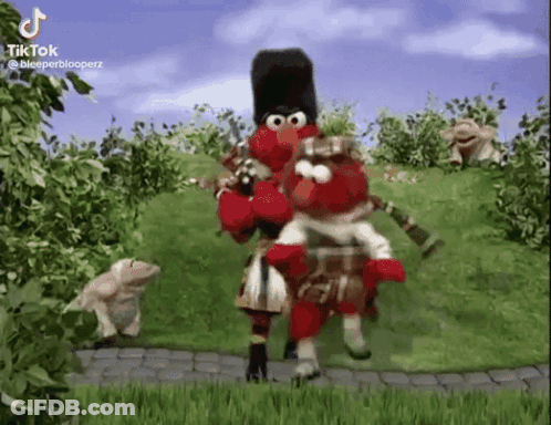 Elmo Is Playing A Bagpipe And Elmo Is Riding Elmo On His Back . GIF