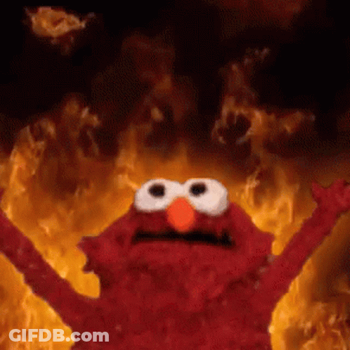 Elmo Is Standing In Front Of A Fire With His Arms Outstretched . GIF