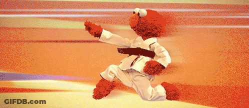 Elmo Is Wearing A White Karate Uniform With A Black Belt Around His Waist GIF