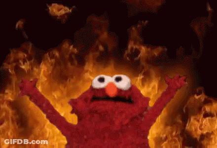 Elmo Standing In Front Of Wall Of Fire GIF