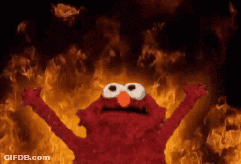 Elmo Standing In Front Of Wall Of Fire GIF