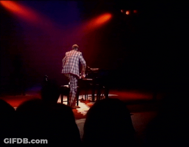 Elton John Standing On Top Of Piano GIF