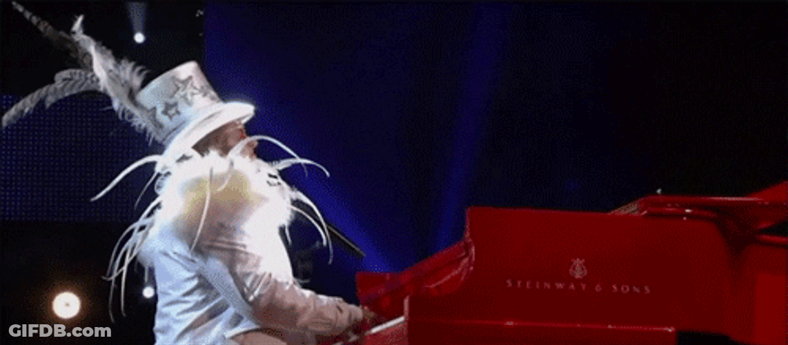 Elton John Wearing Matching White Outfit And Hat GIF
