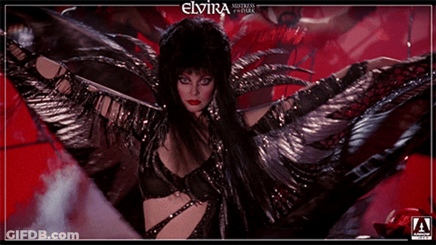 Elvira Spinning While Raising Her Outfit GIF