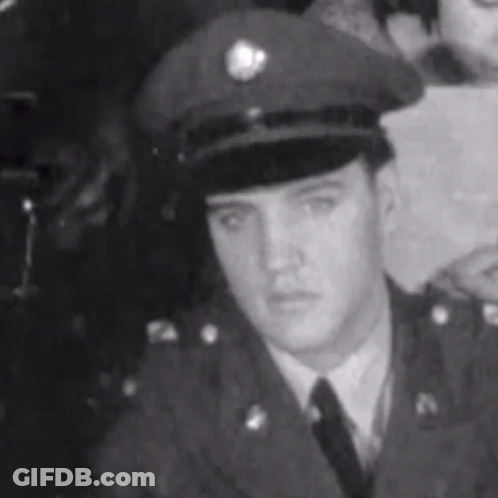 Elvis Presley In Black And White Military Uniform And Hat GIF