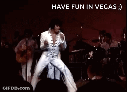 Elvis Presley Is Dancing On Stage In Front Of A Crowd While Playing A Guitar . GIF
