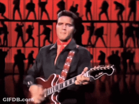 Elvis Presley Is Playing A Guitar On Stage In Front Of A Crowd GIF