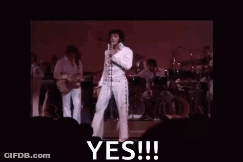Elvis Presley Is Standing On A Stage Holding A Microphone And Says Yes GIF