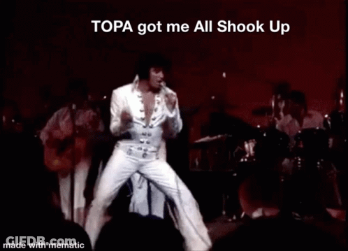 Elvis Presley Performing On Stage With The Words Topa Got Me All Shook Up Above Him GIF