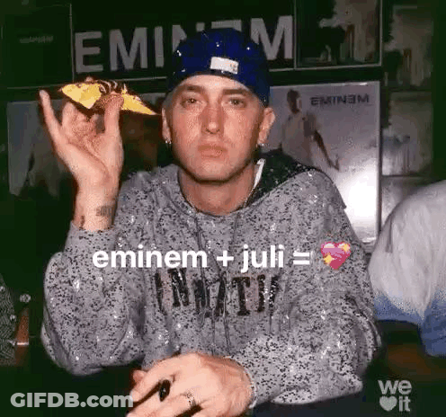 Eminem Is Holding A Piece Of Pizza In His Hand While Wearing A Blue Hat . GIF