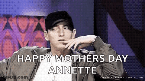 Eminem Is Wearing A Hat And A Jacket And Says `` Happy Mother 'S Day Annette '' While Sitting Down . GIF