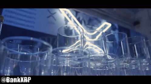 Empty Glasses Lined Up In Front Of Neon Sign GIF