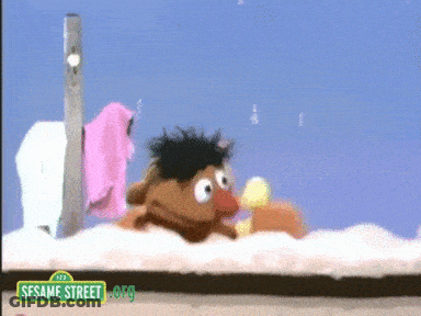Ernie From Sesame Street Laying On Ground GIF