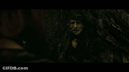 Face Surrounded By Plants In Dark Room GIF