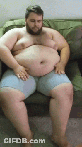 Fat Man Sitting On Couch Hands On Belly GIF
