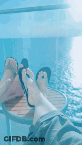 Feet Rest On Table Over Ocean GIF