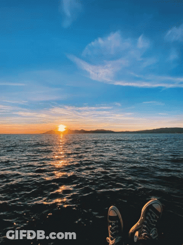 Feet Resting On Shore At Sunset GIF