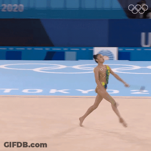 Female Gymnast Performing In Front Of Tokyo Sign GIF