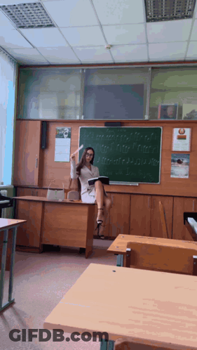 Female Teacher At Desk With Blackboard And Calendar GIF