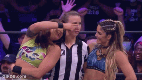 Female Wrestler Covering Eyes Beside Referee GIF
