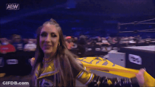 Female Wrestler Holding Yellow Flag In Front Of Crowd GIF