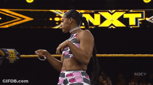 Female Wrestler In Front Of NXT Banner GIF