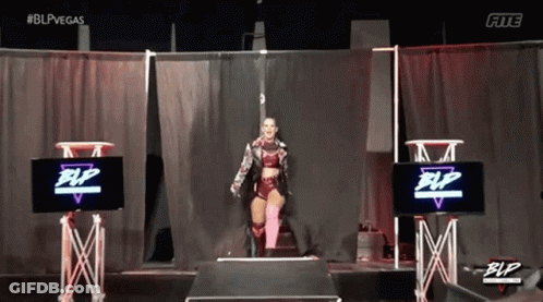 Female Wrestler On Stage In Front Of Screen GIF