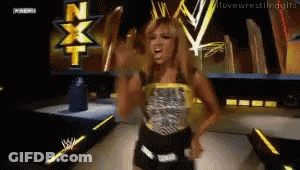 Female Wrestler Standing In Front Of NXT Screen GIF