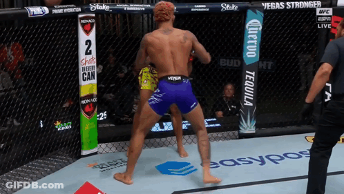 Fighter In Purple Shorts In Front Of Shots In Every Can Sign GIF
