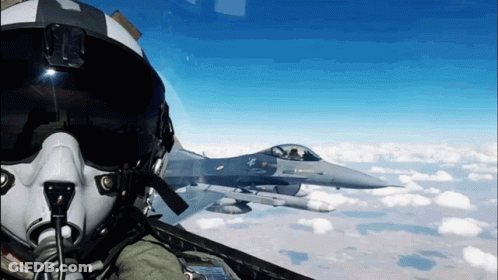 Fighter Jet Flying Behind Pilot In Helmet GIF