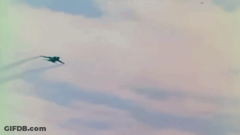 Fighter Jet Flying Through Blue Sky With Clouds GIF