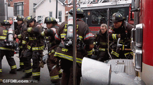 Firefighters Standing In Front Of Fire Truck Number 7 GIF
