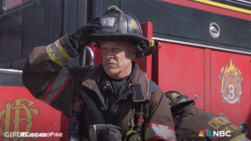 Fireman In Uniform In Front Of Chicago Fire Truck GIF