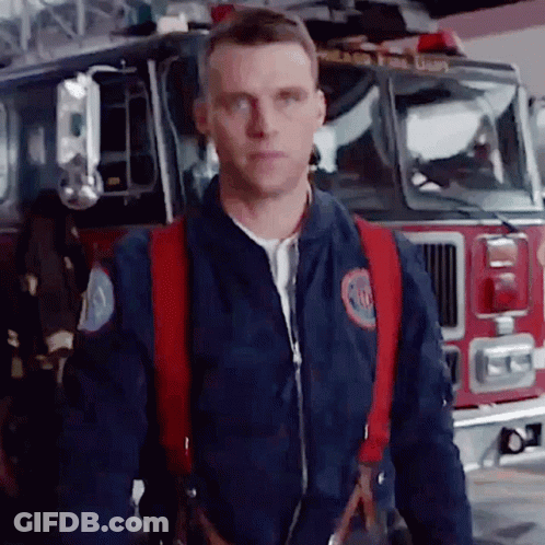 Fireman Standing In Front Of Fire Truck GIF