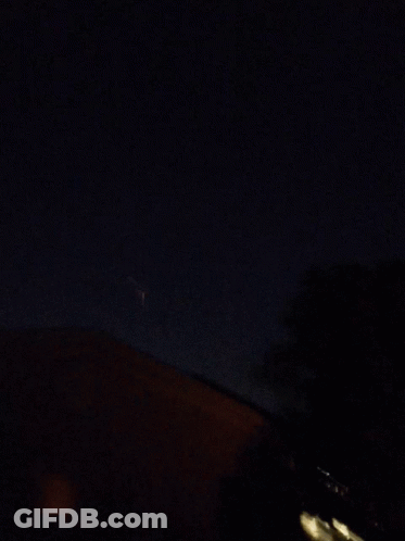 Fireworks Display In Night Sky Over House GIF