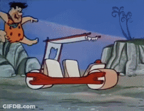 Flintstone Driving Car On Rocky Beach GIF