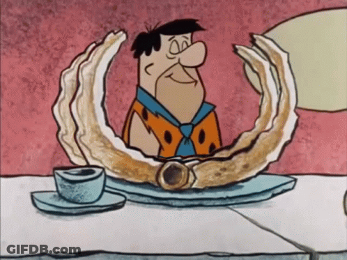 Flintstone Sitting At Table With Oyster GIF