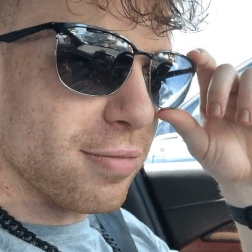 Flirty Man Lifts Sunglasses And Wink Wink GIF