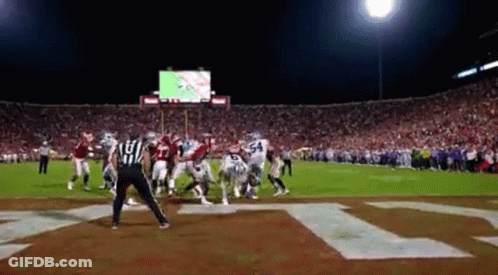 Football Game In Stadium With Letter T On Field GIF