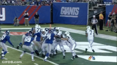Football Game Under Giants Sign GIF