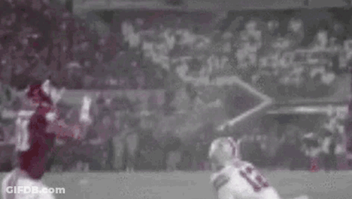 Football Player Catching Ball While Being Tackled GIF