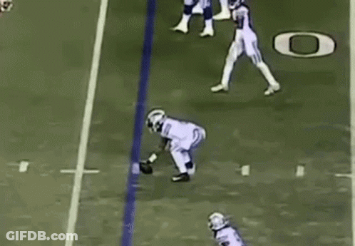 Football Player Catching Ball While Being Tackled GIF