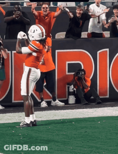 Football Player Celebrating Touchdown Under Uric Banner GIF
