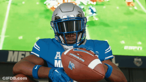 Football Player Holding Ball In Front Of ESPN Screen GIF