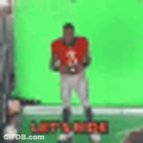 Football Player Holding Football In Front Of Green Screen GIF