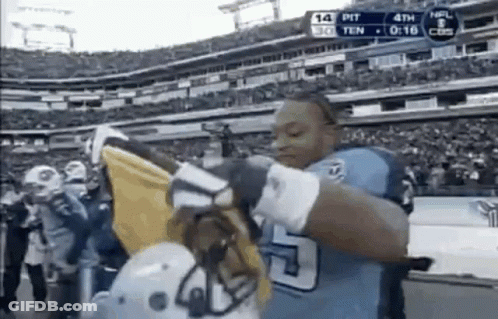 Football Player Holding Helmet And Flag In Front Of Crowd GIF