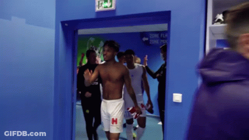 Football Player Holding Helmet In Front Of Crowd GIF