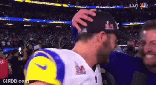 Football Player Holding Trophy In Front Of Verizon Sign GIF
